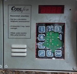 Rozsdás, törött billentyűzetű CODEfon Digital System analóg kaputelefon kültéri egység társasházi falon, hiányzó számgombokkal és korrodált fémburkolattal.